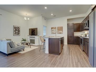 Open concept kitchen and living room with island, stainless steel appliances, and hardwood floors at 9283 Twenty Mile Rd # 403, Parker, CO 80134