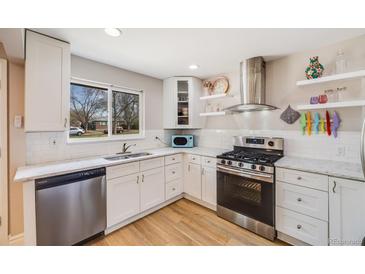 Bright kitchen features white cabinets, stainless steel appliances, and a window with a view at 3237 N Milwaukee St # 8, Denver, CO 80205