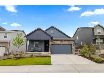 Charming blue two-story home featuring a stone accent, covered porch, attached garage, and landscaped yard at 8132 Mt Harvard Rd, Littleton, CO 80125