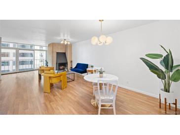 Bright living room features a brick fireplace, hardwood floors, and modern furniture at 1777 Larimer St # 709, Denver, CO 80202