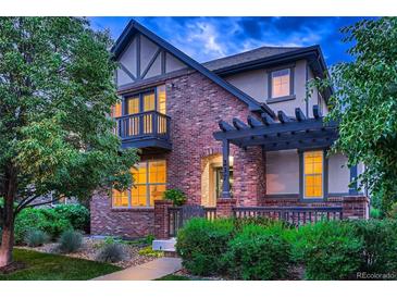 Charming two-story brick home with a cozy front porch and well-maintained landscaping at 237 Dayton St, Denver, CO 80230