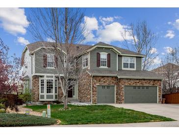 Charming two-story home featuring a stone facade, attached two-car garage, and well-maintained lawn at 1563 Baguette Dr, Castle Rock, CO 80108