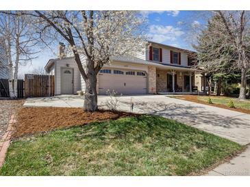 Charming two-story home features a well-manicured lawn, garage, and inviting front porch at 1479 S Jasper St, Aurora, CO 80017