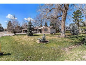 Charming home with a well-manicured front yard and mature trees at 10601 W 78Th Ave, Arvada, CO 80005