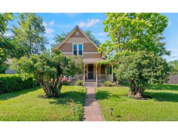 Charming home with a covered front porch and mature landscaping along a stone walkway at 3039 W 22Nd Ave, Denver, CO 80211