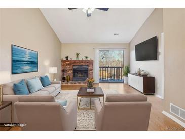 Bright living room with fireplace, sliding glass door to balcony, and neutral decor at 2253 S Buckley Rd # 202, Aurora, CO 80013