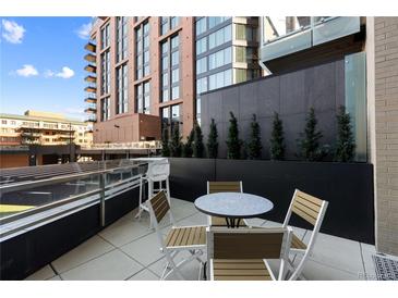 Relaxing outdoor patio with a table, chairs, and beautiful plantings at 1901 Wazee St # 312, Denver, CO 80202