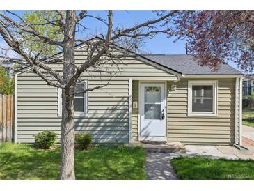 Charming single-story home with light-green siding, a well-manicured lawn, and a welcoming front door at 6819 Reno Dr, Arvada, CO 80002