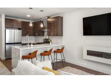 Modern kitchen with stainless steel appliances, sleek cabinetry, quartz countertop, and seating at the island at 1898 S Bannock St # 510, Denver, CO 80223