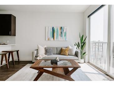 Bright living room featuring a comfortable sofa, modern art, and a coffee table, creating a cozy and inviting space at 1898 S Bannock St # 510, Denver, CO 80223
