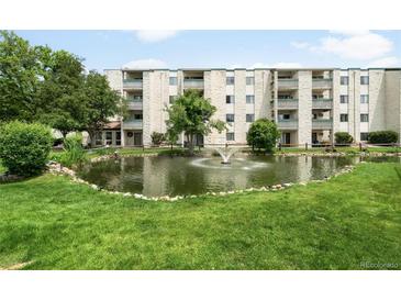 Beautiful exterior view of condo building, including a pond with a fountain and well-manicured landscaping at 7780 W 38Th Ave # 203, Wheat Ridge, CO 80033