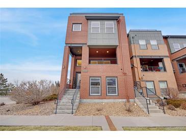 Modern brick home with a striking facade, a covered porch, and clean, minimalist landscaping at 5471 W 97Th Pl # F, Westminster, CO 80020