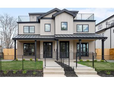 Modern townhouse with a black metal fence, metal roof, and a low-maintenance landscaped front yard at 2520 S Cherokee St, Denver, CO 80223