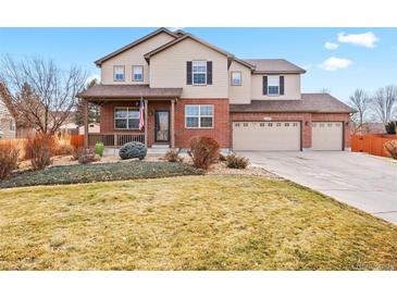 Two-story brick home with a landscaped yard and attached two-car garage at 6100 E 133Rd Ave, Thornton, CO 80602