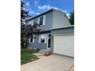 Charming two-story home with light blue siding, white trim, and a well-maintained lawn at 10050 Holland Ct, Broomfield, CO 80021