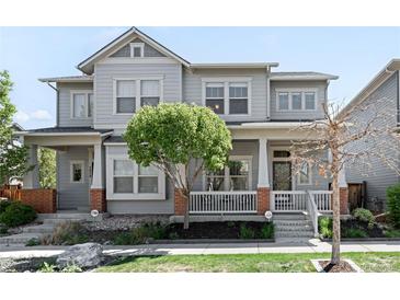 Charming gray two-story home featuring a welcoming front porch and well-maintained landscaping at 5450 Uinta St, Denver, CO 80238