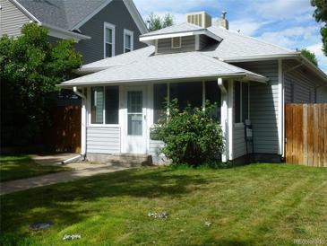 Charming bungalow with a well-manicured lawn, porch, and light gray siding at 4353 Wolff St, Denver, CO 80212
