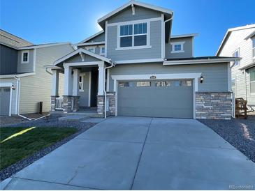 Two-story house with gray siding, attached garage, and landscaped lawn at 5598 Wisteria Ave, Firestone, CO 80504