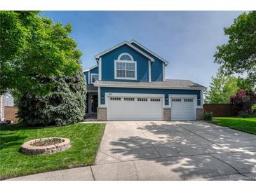Charming two-story home with a three car garage, manicured lawn and a flower garden in the front yard at 901 Sage Sparrow Cir, Highlands Ranch, CO 80129