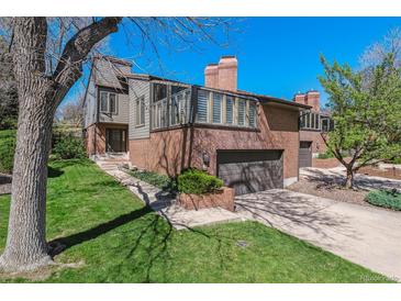 Charming two-story home with brick and gray siding, attached garage and mature trees at 6969 W Yale Ave # 81, Denver, CO 80227