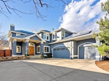 Inviting blue two-story home with a three car garage and large concrete driveway at 4825 6Th St, Boulder, CO 80304