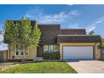 Charming two-story home with a well-manicured lawn and a two-car garage on a sunny day at 234 Cypress Cir, Broomfield, CO 80020