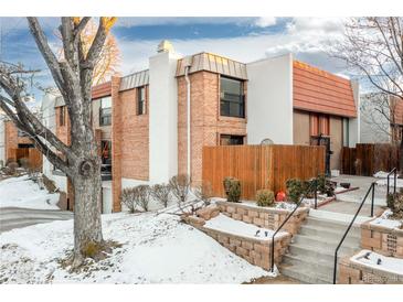 Brick townhouse exterior with steps leading to entrance and wooden fence at 6462 E Bates Ave, Denver, CO 80222