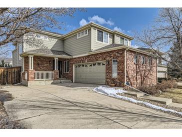 Charming two-story home featuring a brick and siding exterior, attached garage, and well-maintained front yard at 3242 S Jebel Way, Aurora, CO 80013