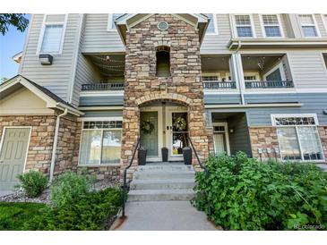 Inviting condo entrance featuring a stone facade, steps leading to the front door, and well-maintained landscaping at 474 Black Feather Loop # 419, Castle Rock, CO 80104