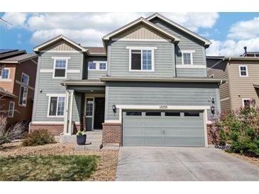 Charming two-story home featuring a well-maintained lawn, two-car garage and appealing curb appeal at 12233 Hannibal St, Commerce City, CO 80603