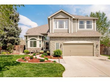 Charming two-story home with stone accents, manicured lawn, and attached two car garage at 1210 Snowberry Ln, Broomfield, CO 80020