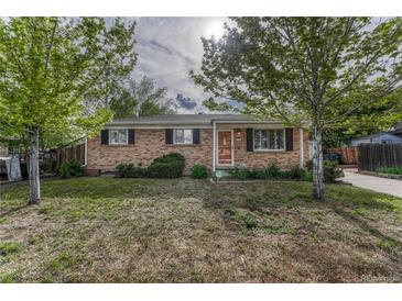 Charming single-story brick home with lush front yard and mature trees in a quiet neighborhood setting at 11957 Claude Ct, Northglenn, CO 80233