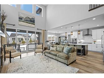 Bright open-concept living space featuring large windows, comfortable seating, and seamless flow to the kitchen and dining area at 624 Simmental Loop, Castle Rock, CO 80104