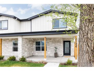 Inviting two-story home featuring a charming stone porch and contemporary design elements at 2134 S Galapago, Denver, CO 80223