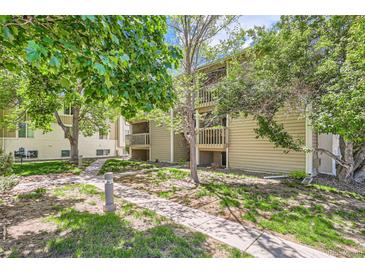 Charming condo exterior with lush landscaping, mature trees, and inviting walking paths at 4070 S Atchison Way # 101, Aurora, CO 80014