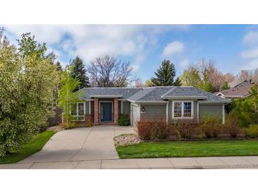 Charming single-story home featuring a well-manicured lawn, mature trees, and a welcoming front entrance at 2330 Sandpiper Dr, Lafayette, CO 80026