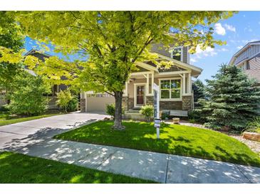 Charming home featuring a well-maintained lawn, lovely landscaping, and inviting curb appeal at 16404 E 117Th Ave, Commerce City, CO 80022