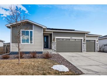 Charming single-story home featuring a three-car garage, stone accents, and professionally landscaped yard at 4128 Castle Vista Ln, Castle Rock, CO 80104