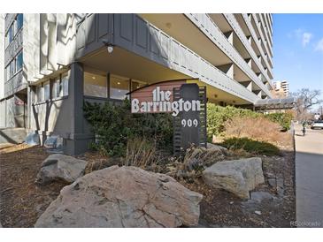 Exterior shot showcasing 'The Barrington' sign with stone landscaping in front of the building at 909 N Logan St # 10C, Denver, CO 80203