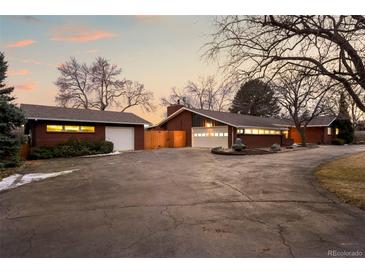 Spacious brick home with multiple garage spaces and large concrete driveway on a treed lot at 7382 W Stanford Ave, Littleton, CO 80123