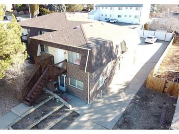 Two story brick building showing front stairway and small balcony and parking area at 2241 Dexter Dr # 2, Longmont, CO 80501
