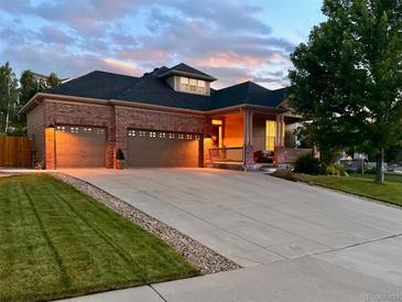 Charming brick home featuring a large driveway, attached three-car garage, and welcoming covered front porch at 1762 Granger Cir, Castle Rock, CO 80109