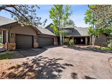 Charming home with a three car garage, a driveway, and stone details at 1570 Blakcomb Ct, Evergreen, CO 80439