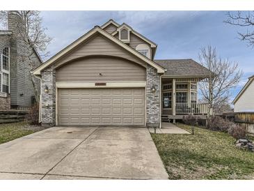 Charming home featuring a two-car garage, neutral paint, brick accents, and a cozy front porch at 21562 Omaha Ave, Parker, CO 80138