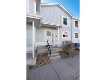 Charming light blue townhouse featuring a secure front door and well-maintained landscaping at 6240 Everett Ct # B, Arvada, CO 80004