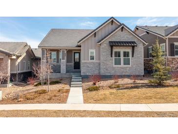 Charming single-story home featuring stone accents, a well-manicured front yard, and a welcoming entryway at 997 Brocade Dr, Highlands Ranch, CO 80126