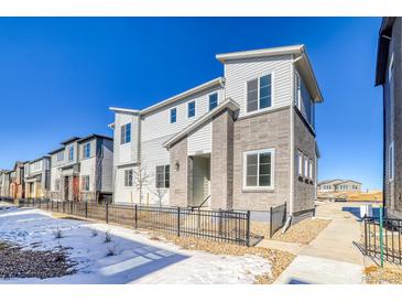 Charming three-story home with modern architecture and a well-maintained front yard and a wrought iron fence at 23970 E 41St Ave, Aurora, CO 80019
