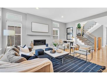 Bright living room featuring a modern fireplace and an open staircase design at 82 Oneida St, Denver, CO 80230