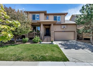 Inviting two-story home featuring a well-manicured lawn, covered porch, and attached two car garage at 21658 E Tallkid Ave, Parker, CO 80138