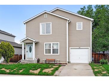 Charming two-story home with neutral siding, landscaped front yard, and a convenient attached one car garage at 1419 Swan Ave, Brighton, CO 80601